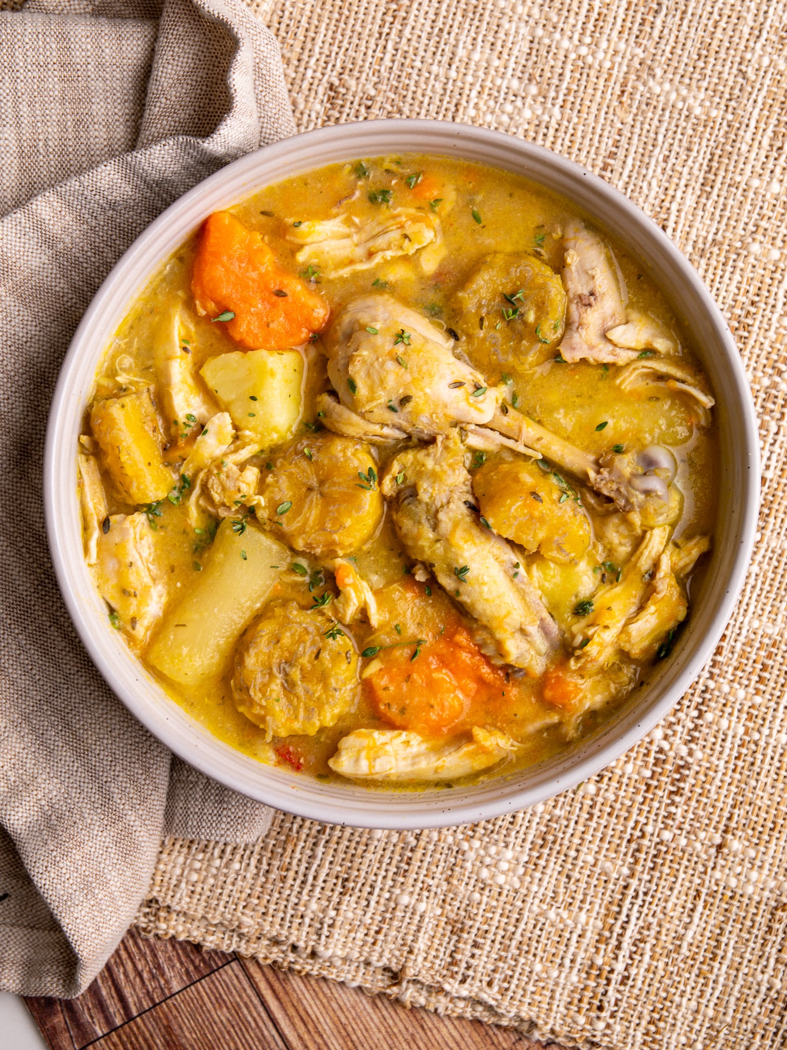 Caribbean chicken soup with root vegetables, plantains, and bone-in chicken in a rich golden broth