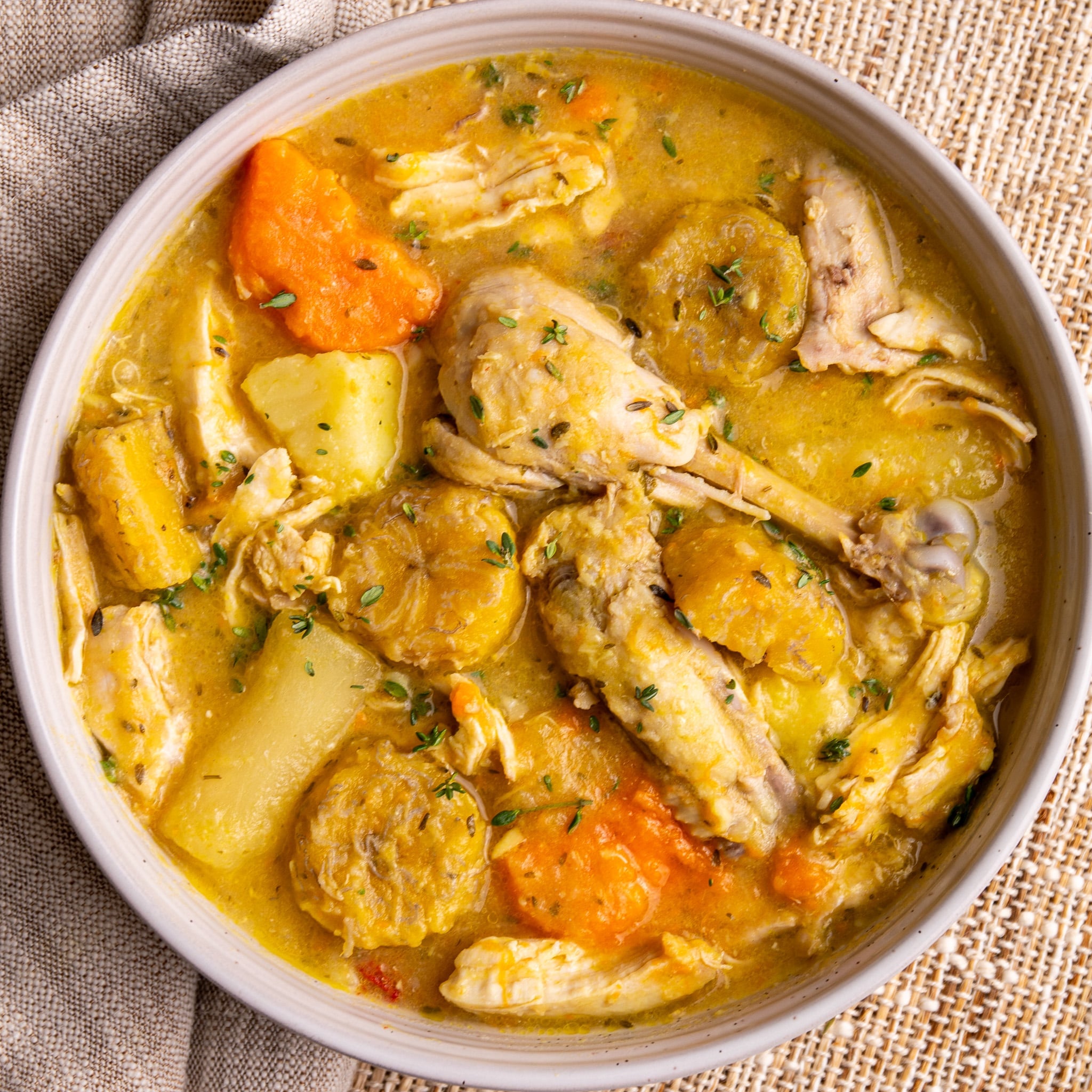 Caribbean chicken soup with root vegetables, plantains, and bone-in chicken in a rich golden broth