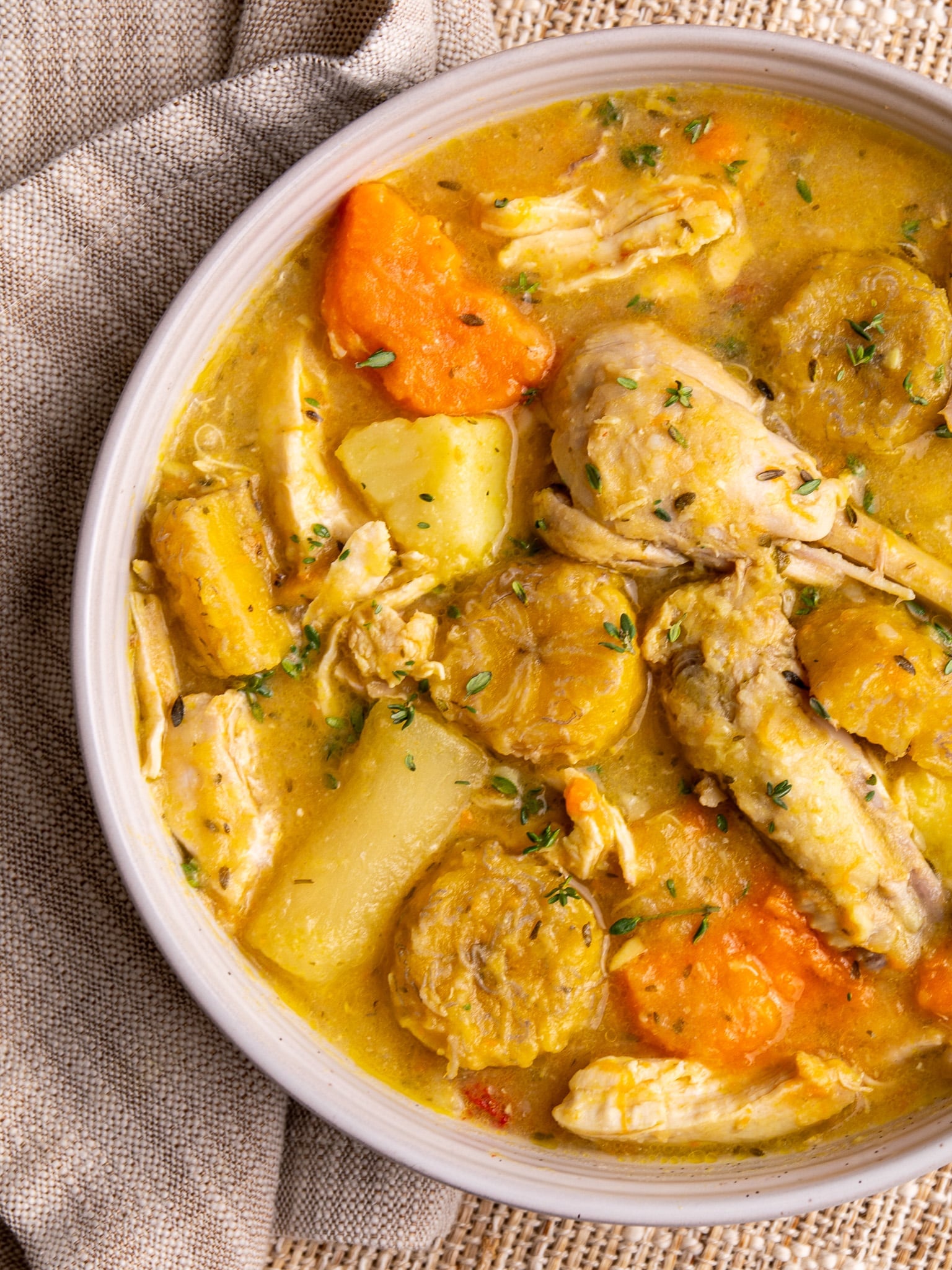 Caribbean chicken soup with root vegetables, plantains, and bone-in chicken in a rich golden broth