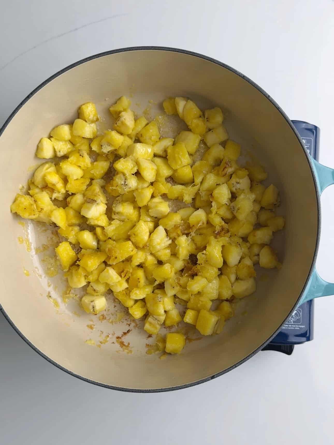 diced yellow plantains tossed around in a skillet. Some of them are beginning to get brown.