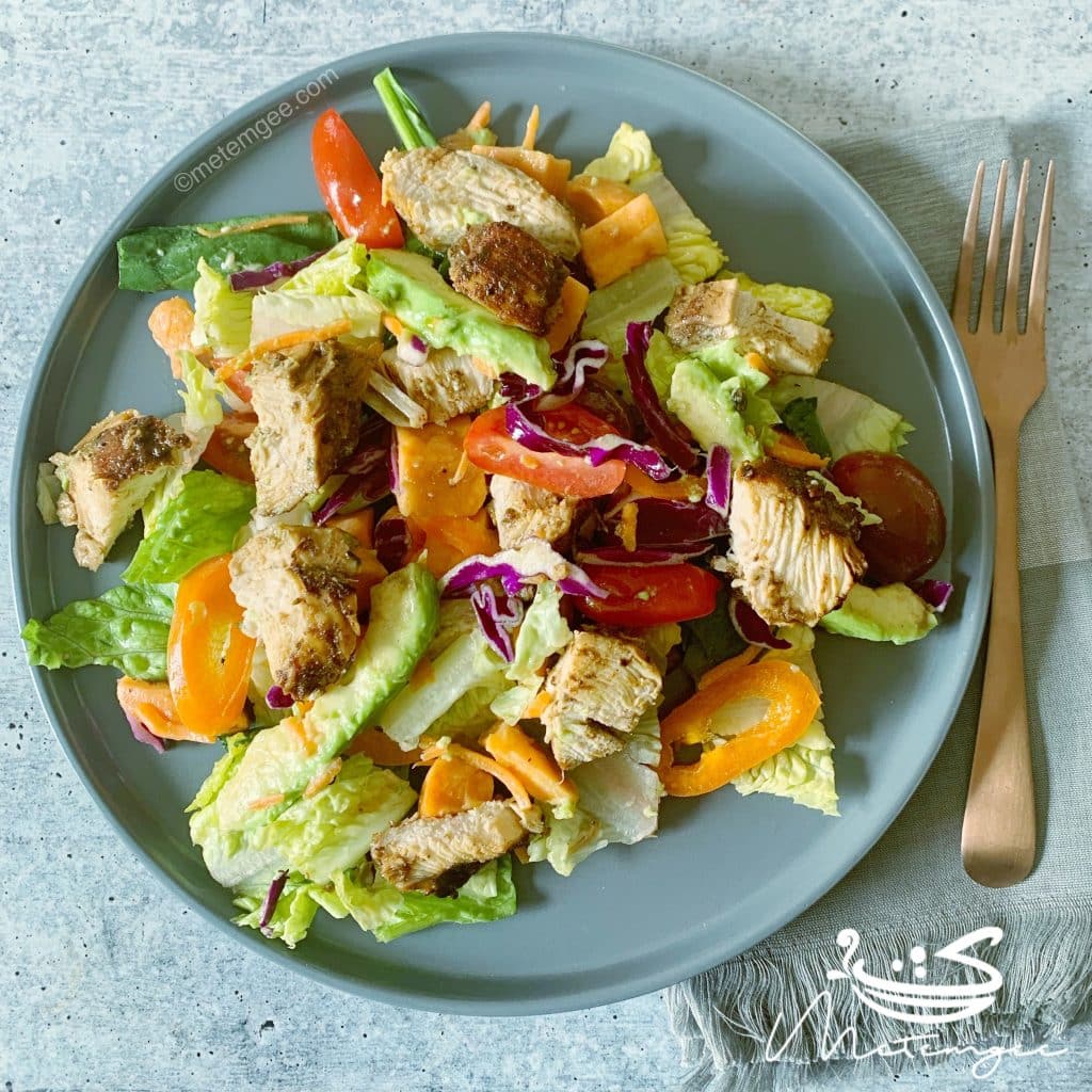 chopped up jerk chicken breast with salad
