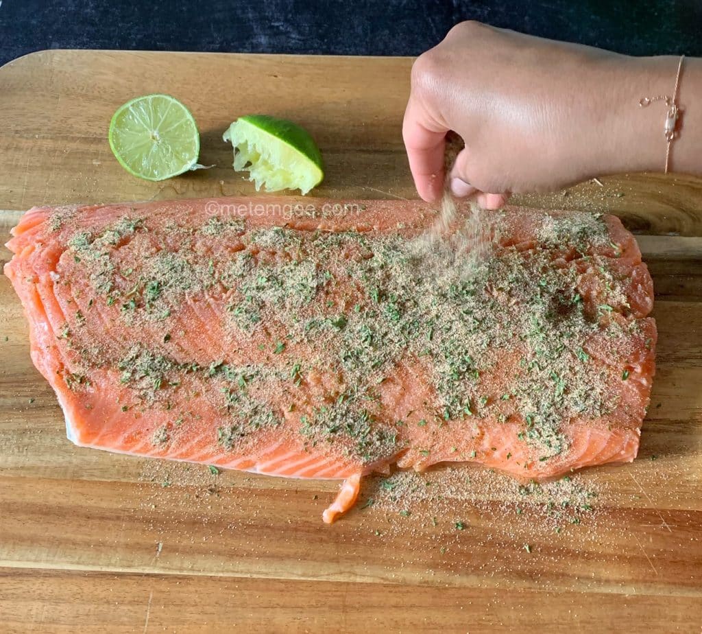 applying dry rub to salmon filet before broiling