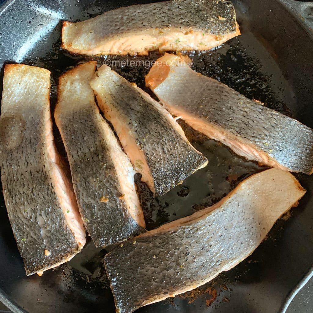 salmon filets being pan seared flesh side down 