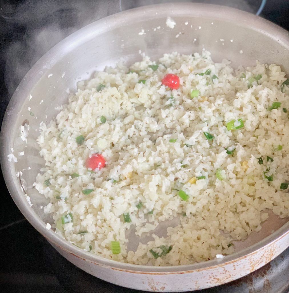 cooked cauliflower rice in a pot before adding yellow split peas
