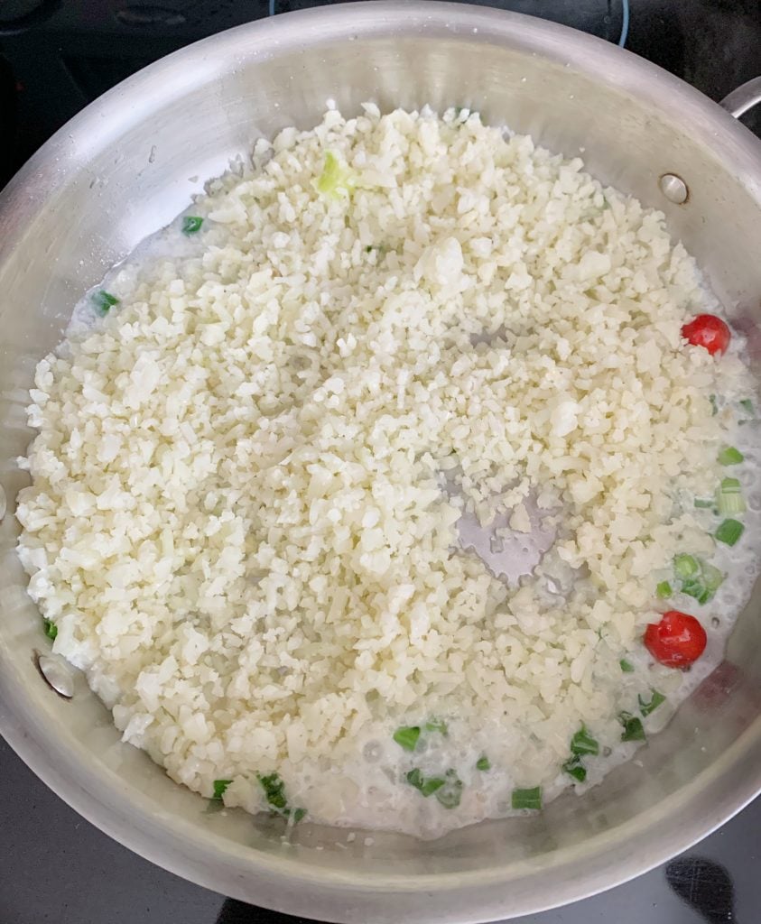 cauliflower rice added to a pot