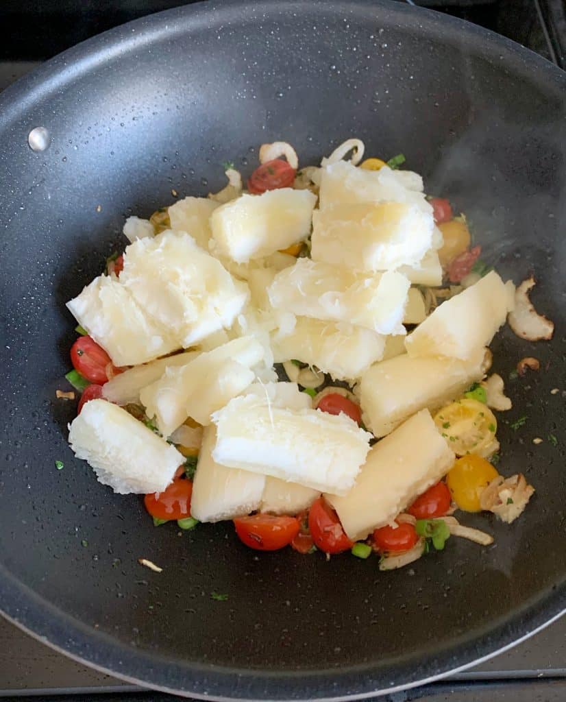 cassava added to a wok pan with sautéed vegetables