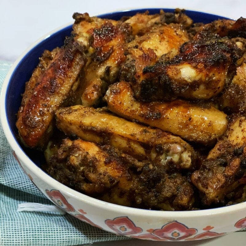 A side view of jerk chicken wings in a bowl