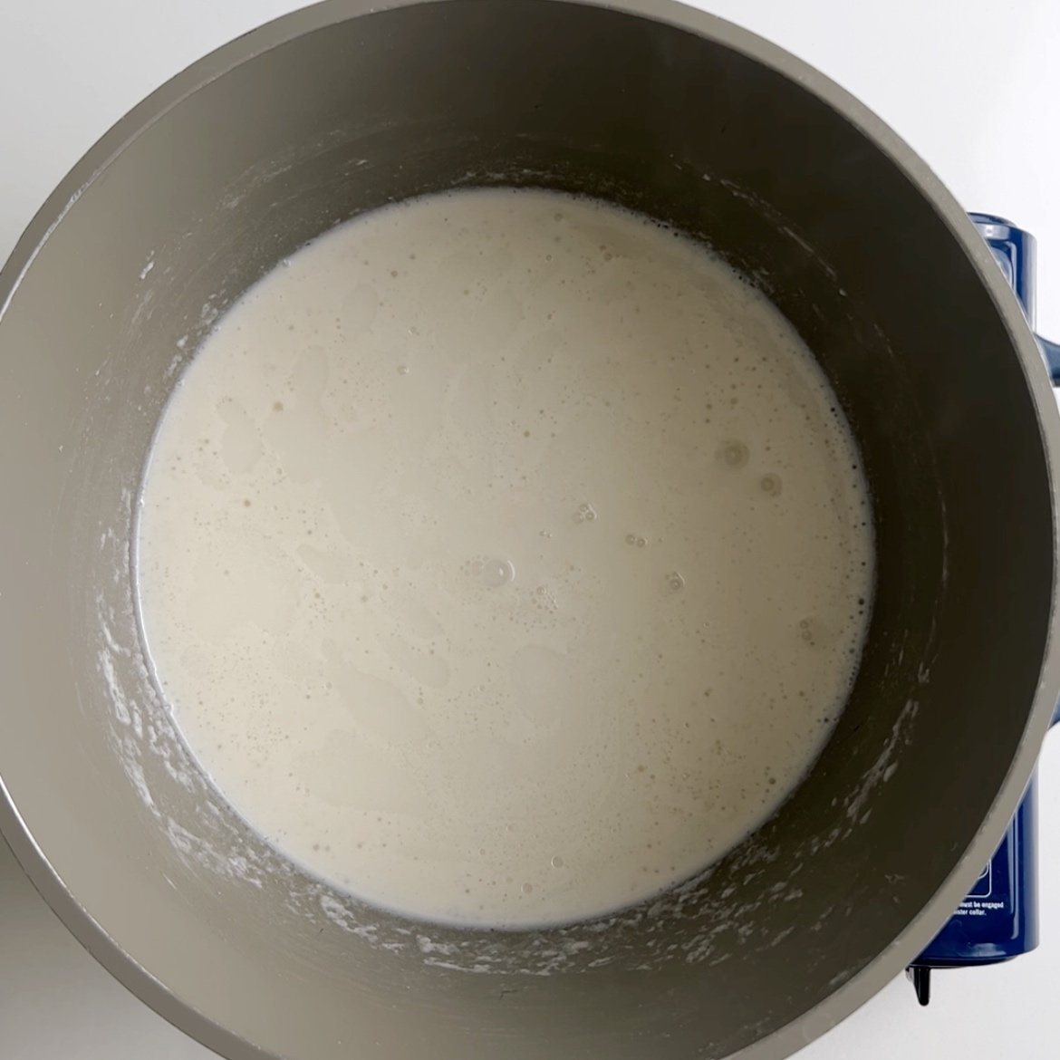 coconut milk simmering in a gray pot