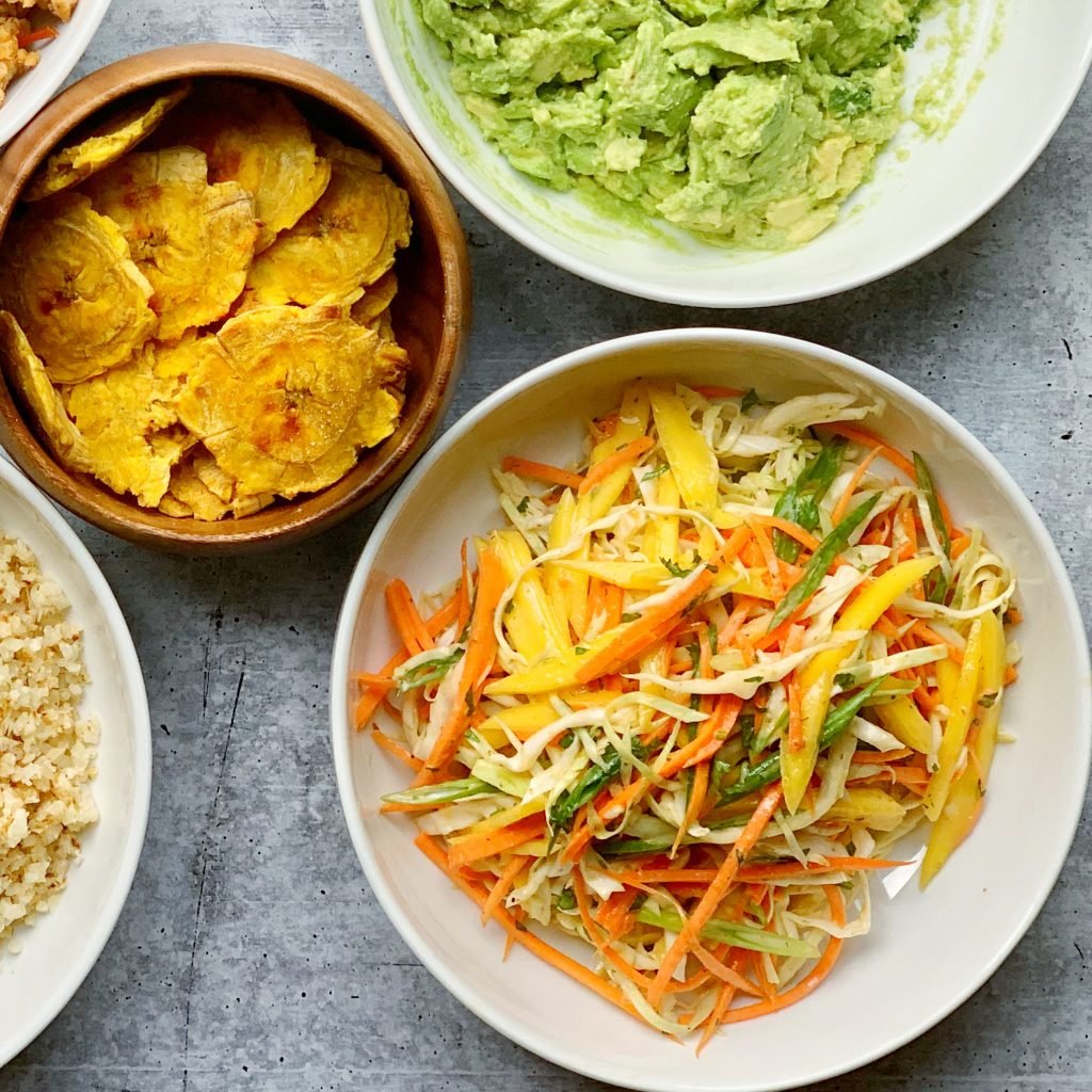 plated mango slaw among an assortment of other dishes