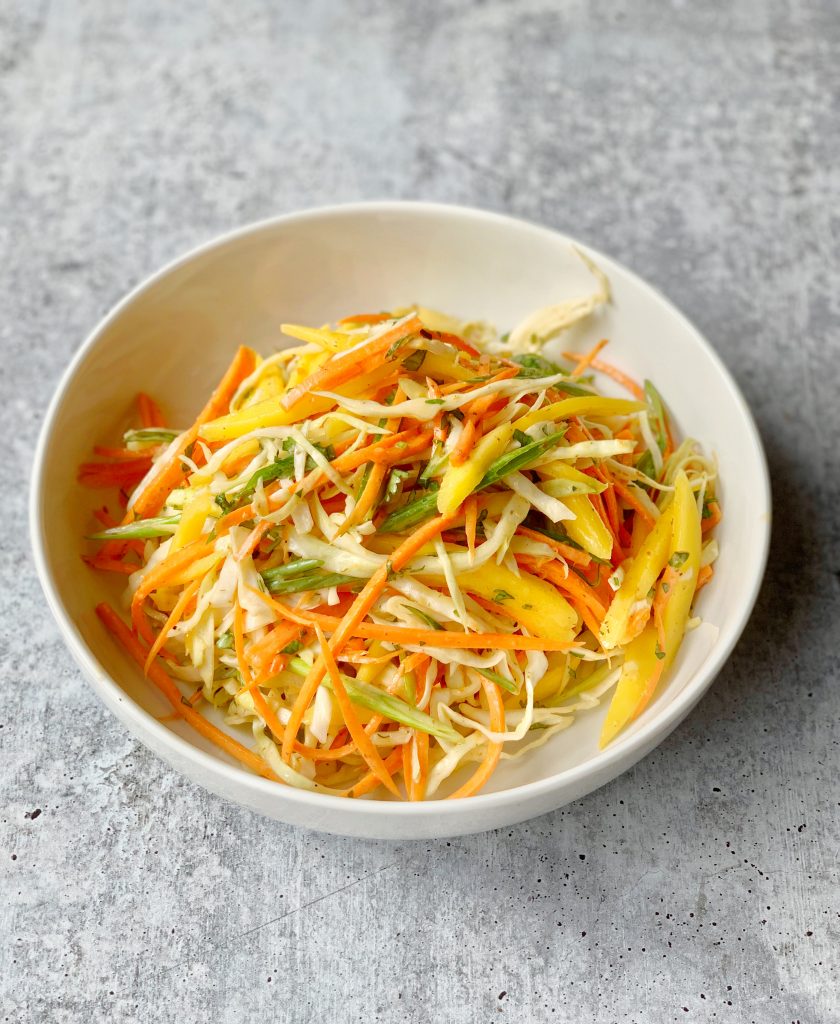 a bowl of cabbage, carrot and mango slaw