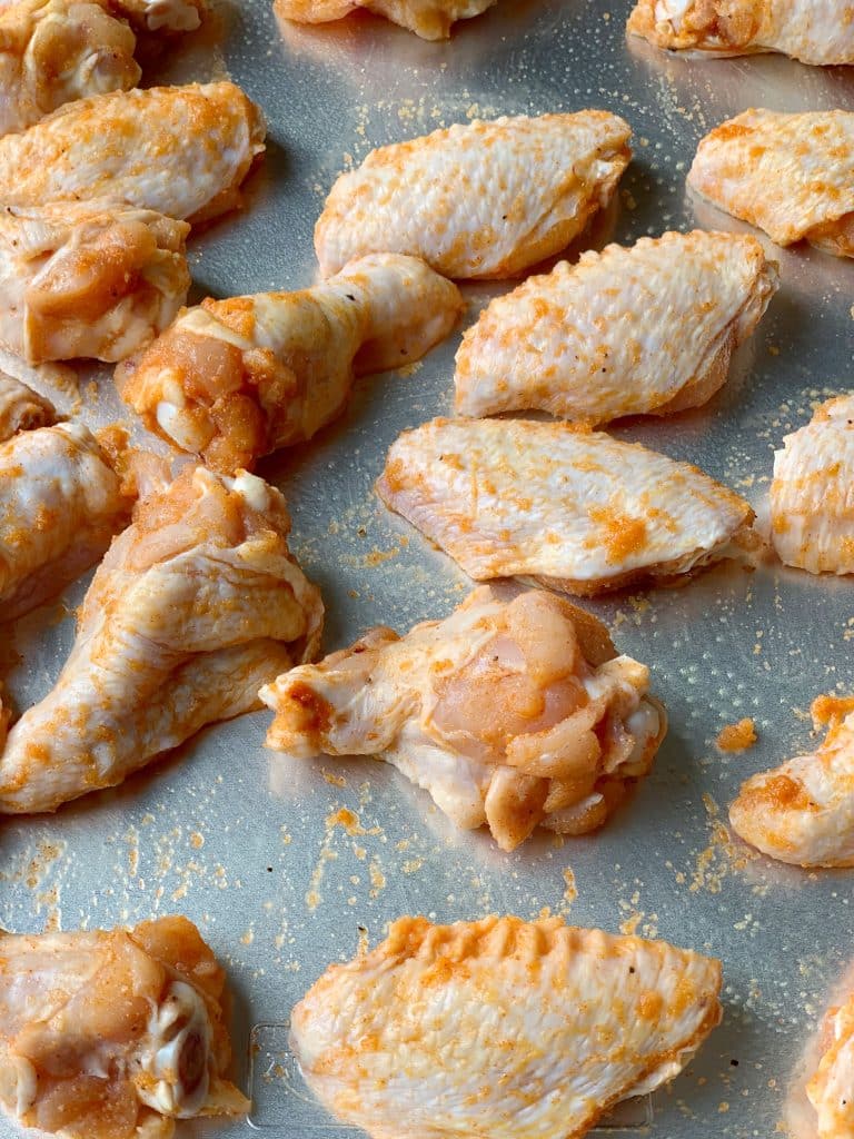 seasoned chicken wings on a baking sheet