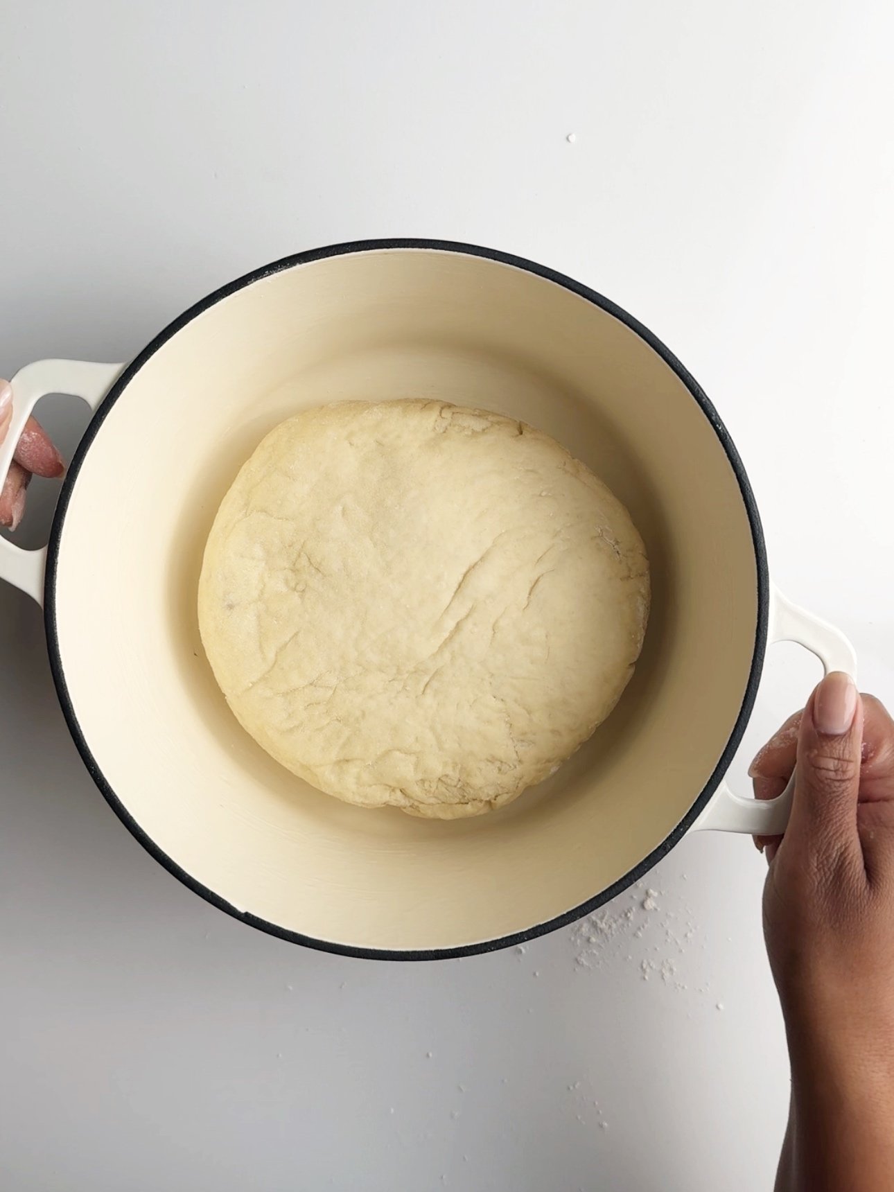 A white cast iron dutch oven with the pot bake ready to be cooked.
