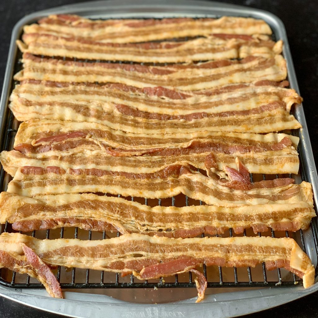 bacon strips glazed with teriyaki sauce on a wire rack over a baking sheet