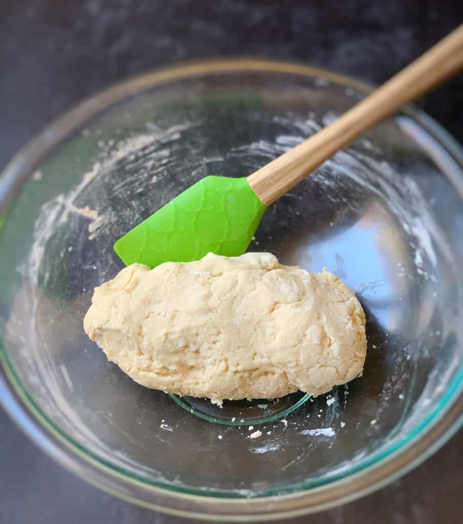 dough ball for gluten free bake, in a bowl with a green spatula