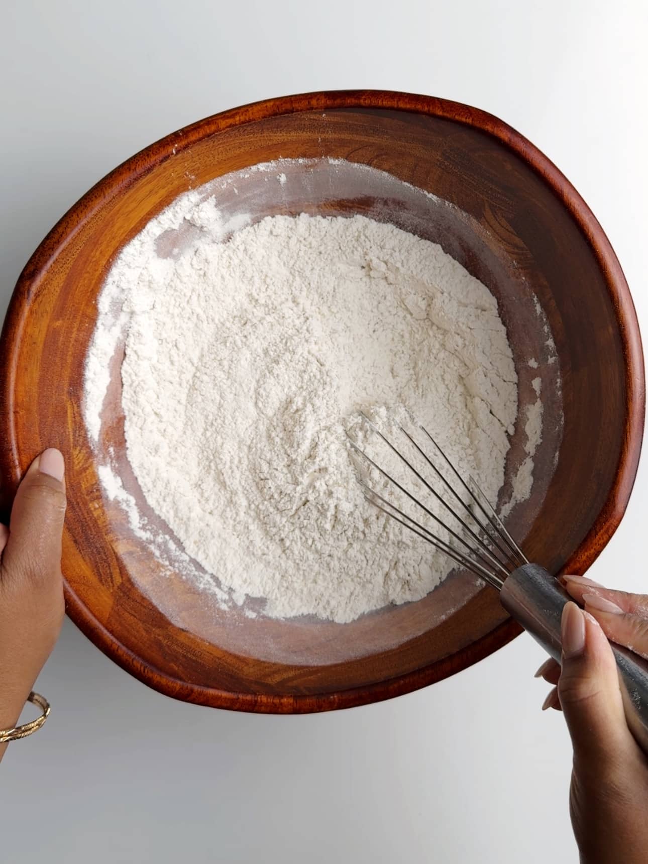 Using a whisk to bring together the dry ingredients to make pot bake.