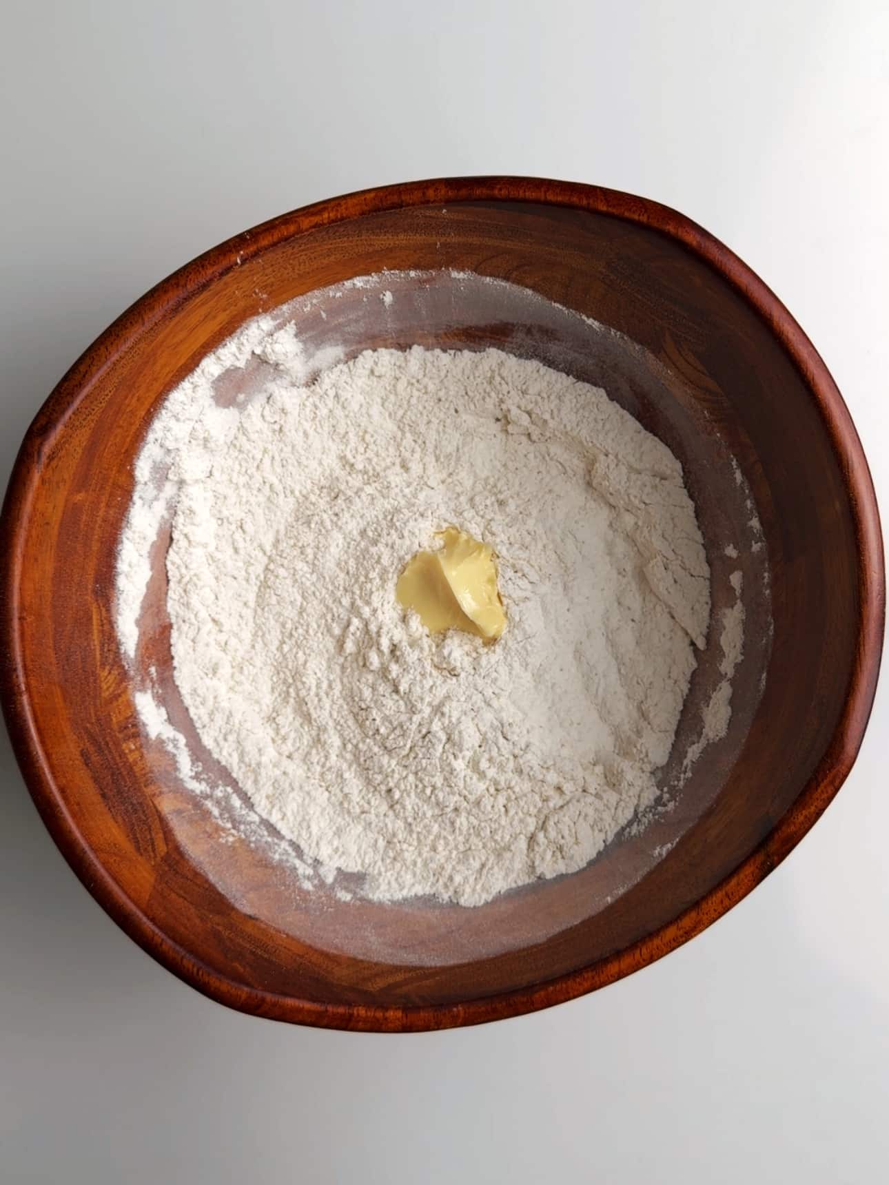 Adding butter to the dry ingredients for Guyanese pot bake.