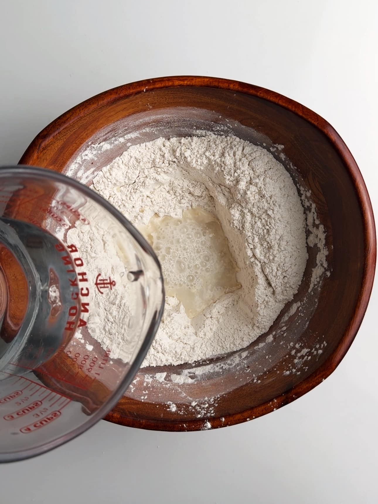Pouring water into the dry ingredients to make pot bake.