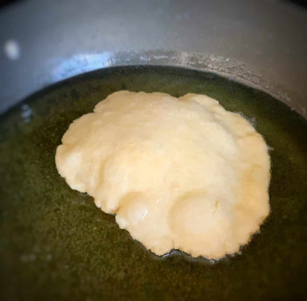 close up view of dough frying in pan 
