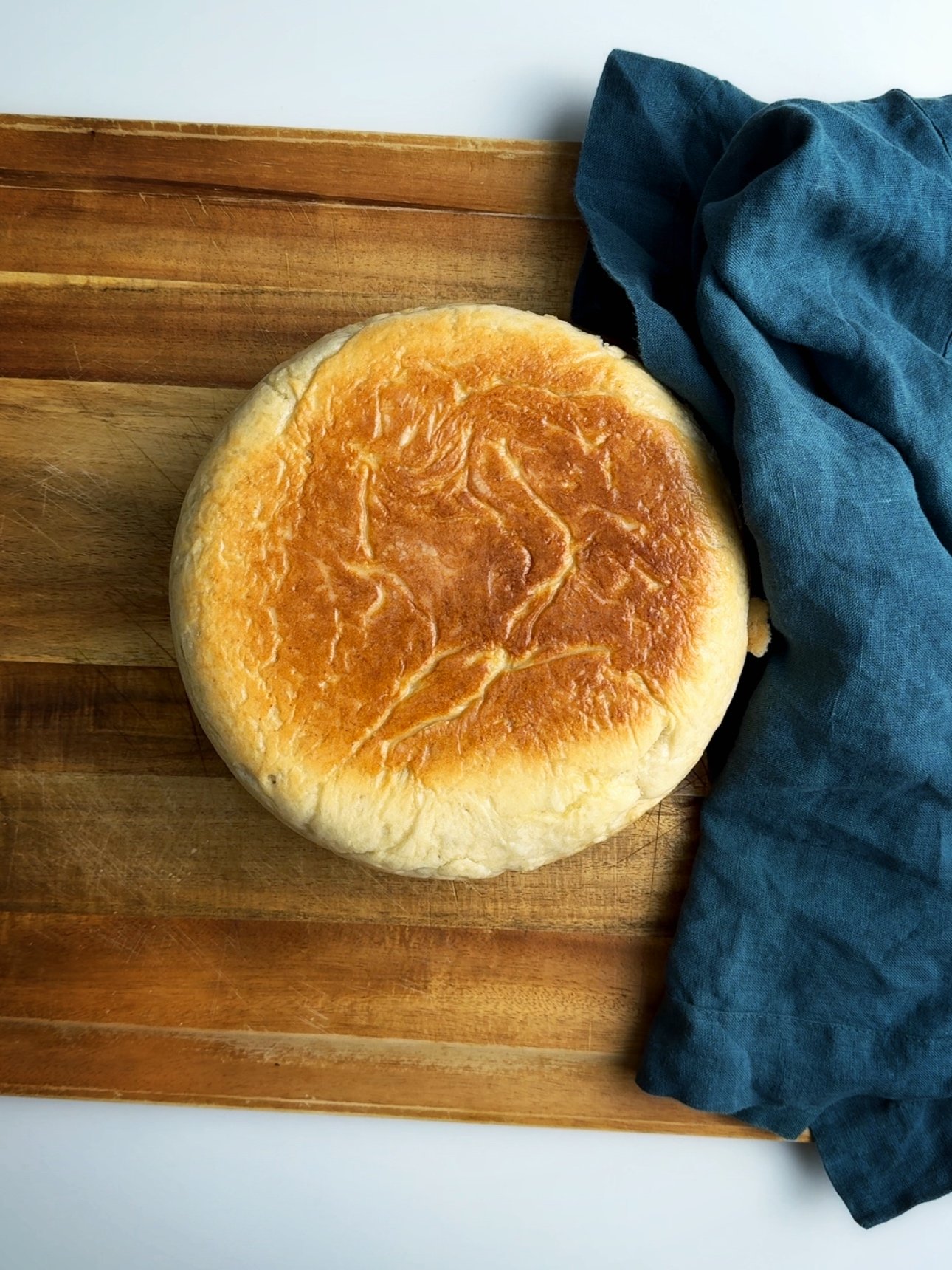 Finished pot bake on a wooden cutting board with a blue napkin to the right