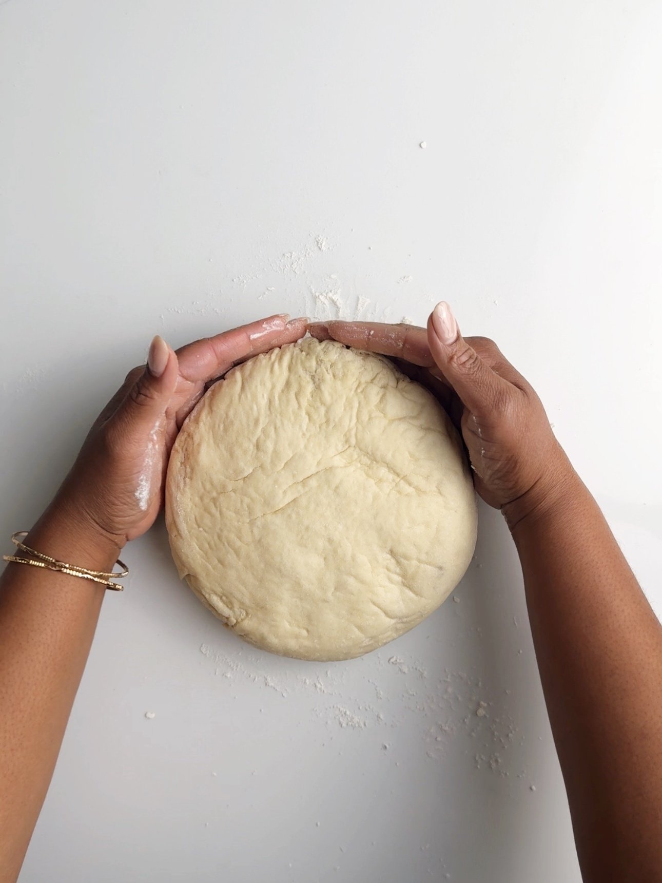 Hands shaping the pot bake into a circle.