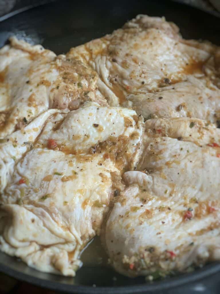 close up view of marinated jerk chicken thighs in a skillet