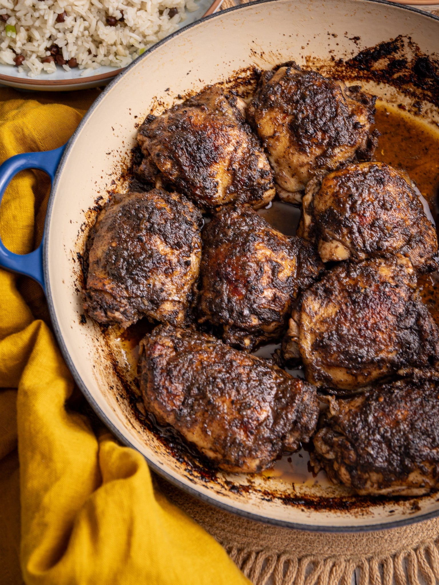 Jerk chicken thighs baked in the oven with a rich, spicy crust in a pan