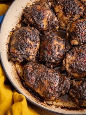 Jerk chicken thighs baked in the oven with a rich, spicy crust in a pan