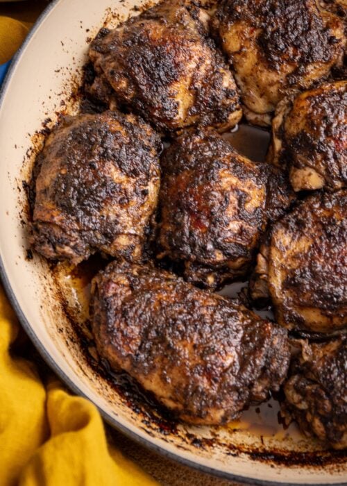 Jerk chicken thighs baked in the oven with a rich, spicy crust in a pan