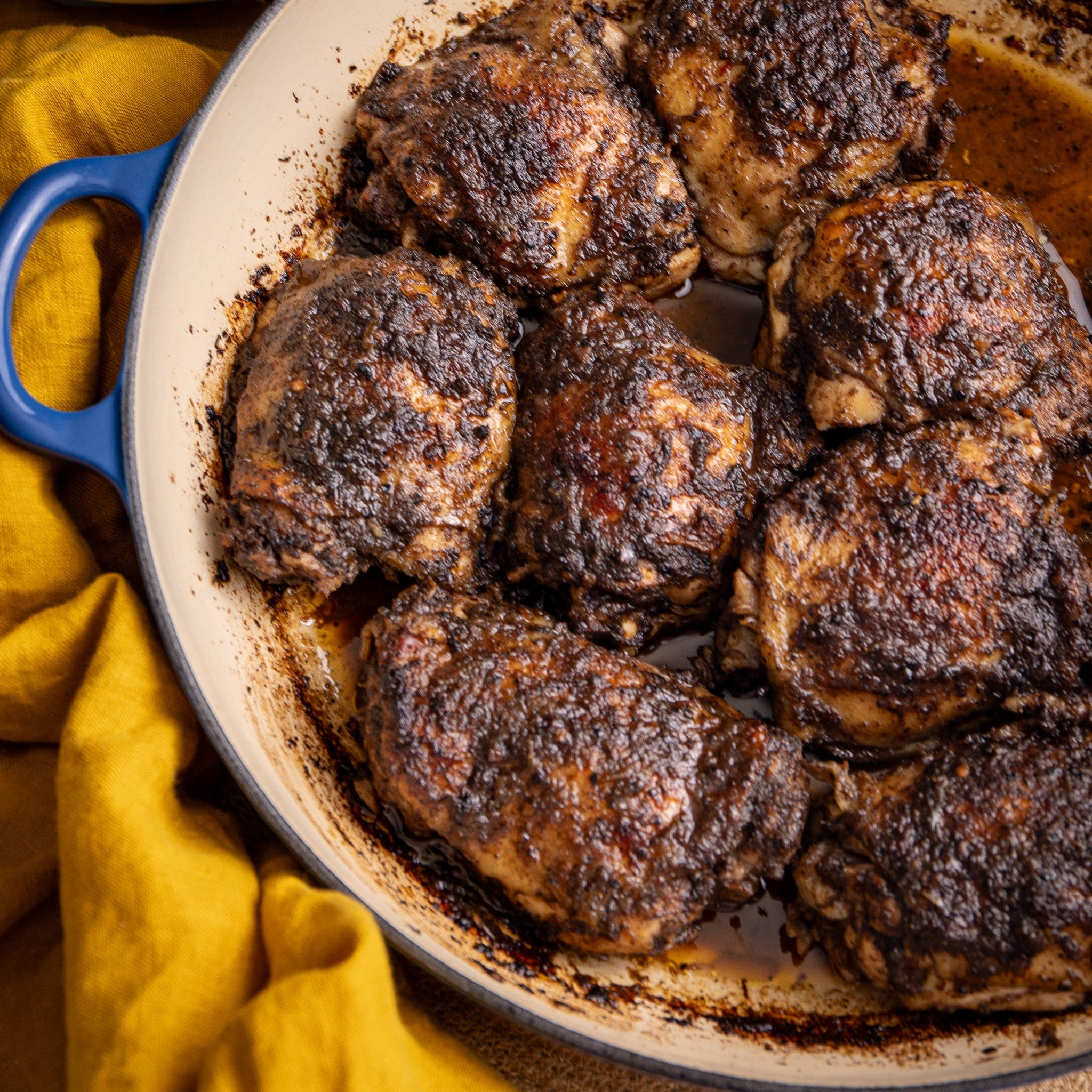 Jerk chicken thighs baked in the oven with a rich, spicy crust in a pan