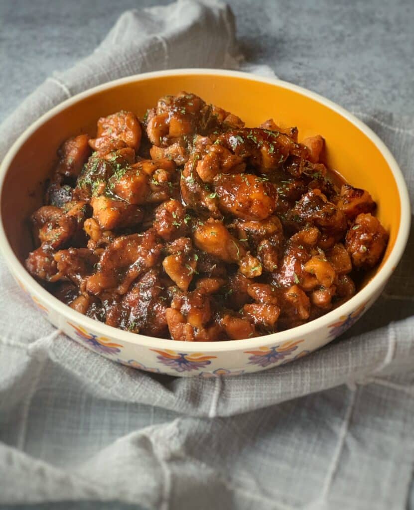 a bowl of boneless brown stew chicken