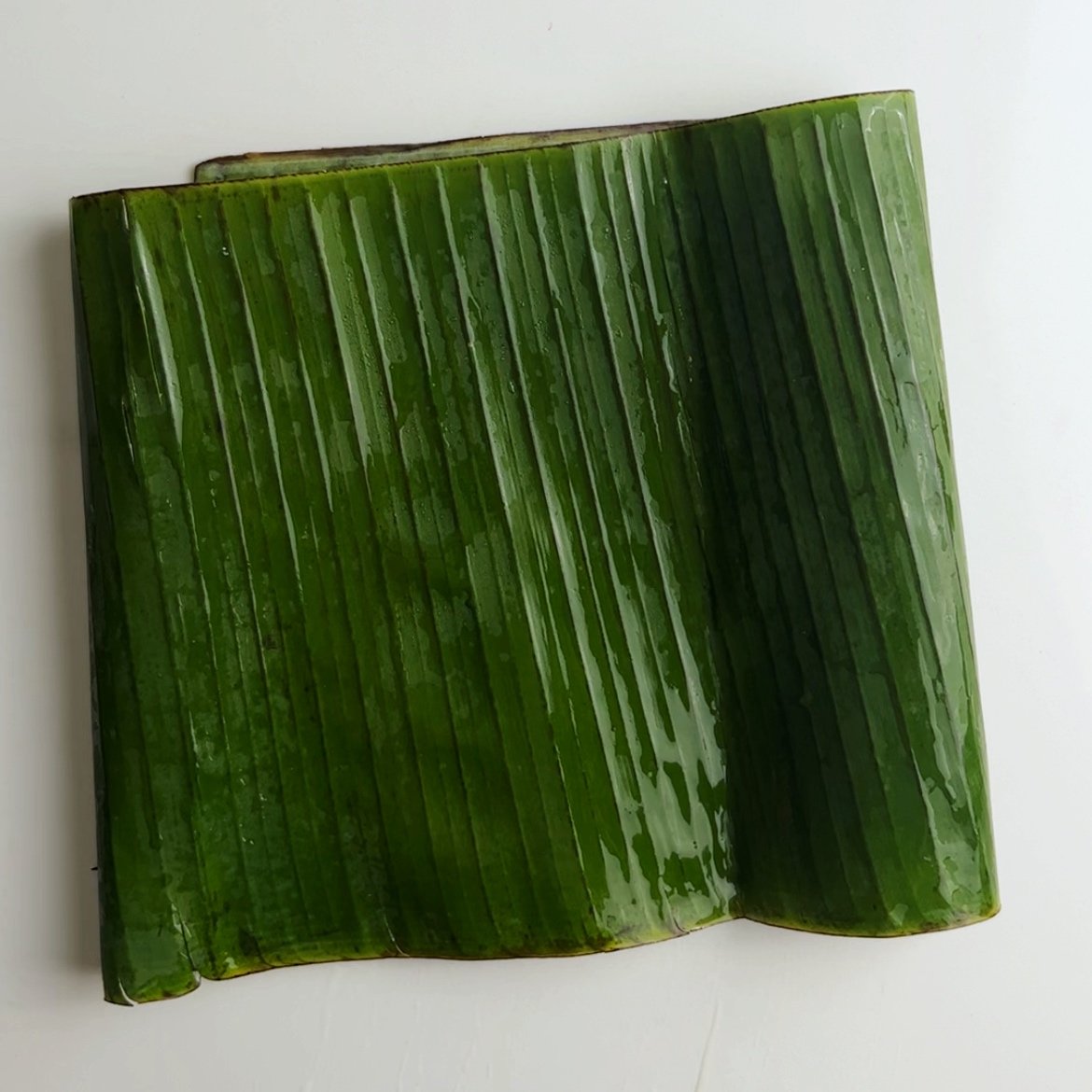 rolled up banana leaves on a white surface