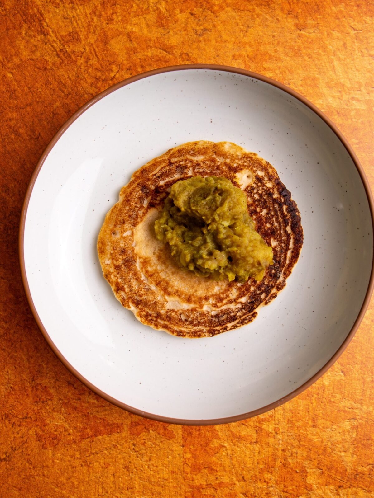 Chota in a plate with aloo curry on top. 