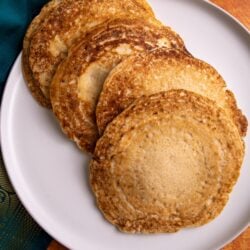 Guyanese chotas/dosa on a plate with a green and orange back ground