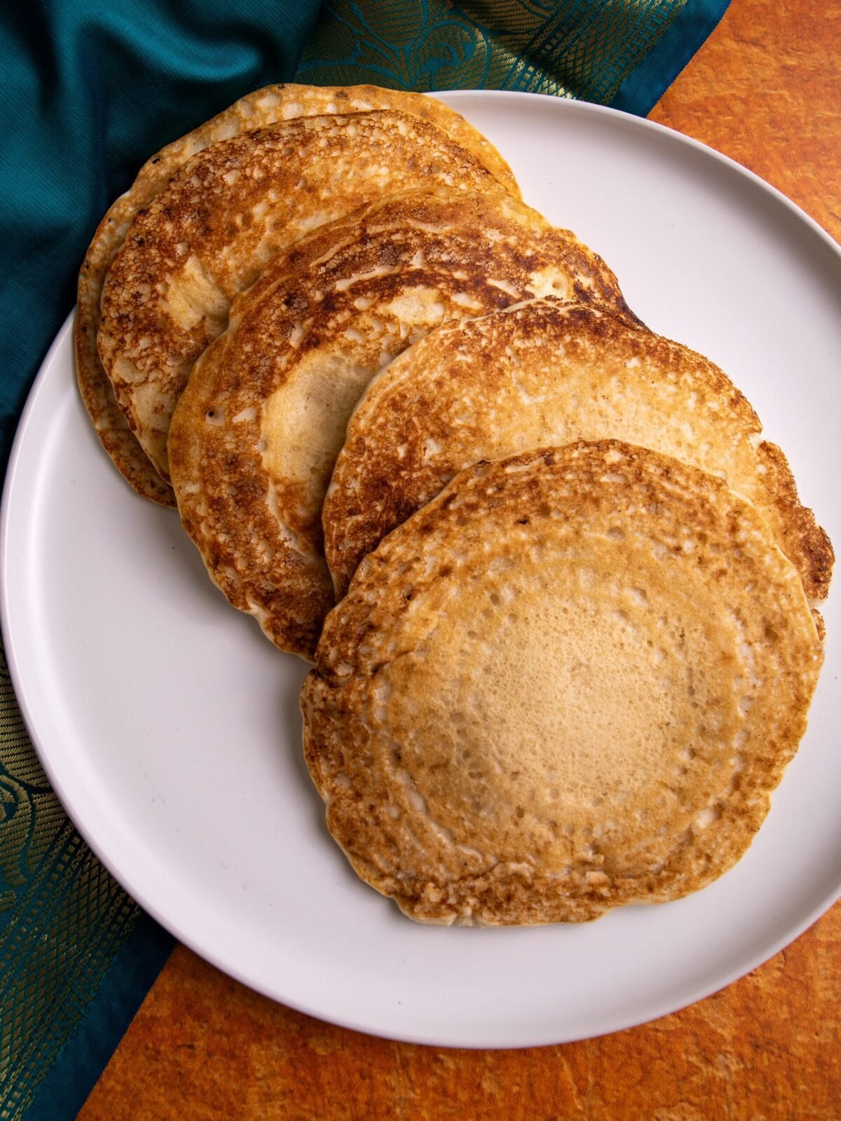 Guyanese chotas/dosa on a plate with a green and orange back ground