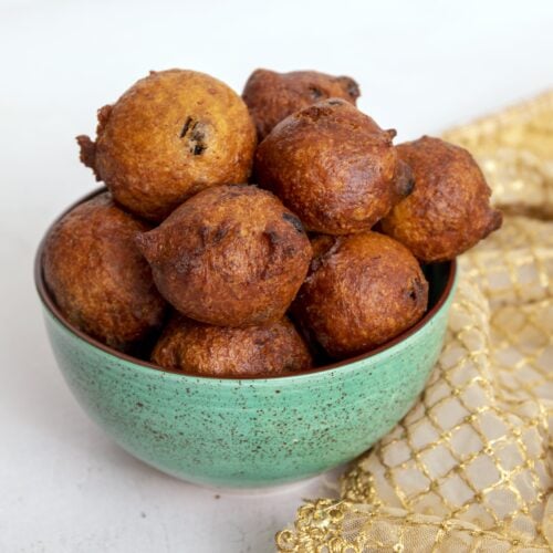 golden brown fried gulgula balls in a green bowl