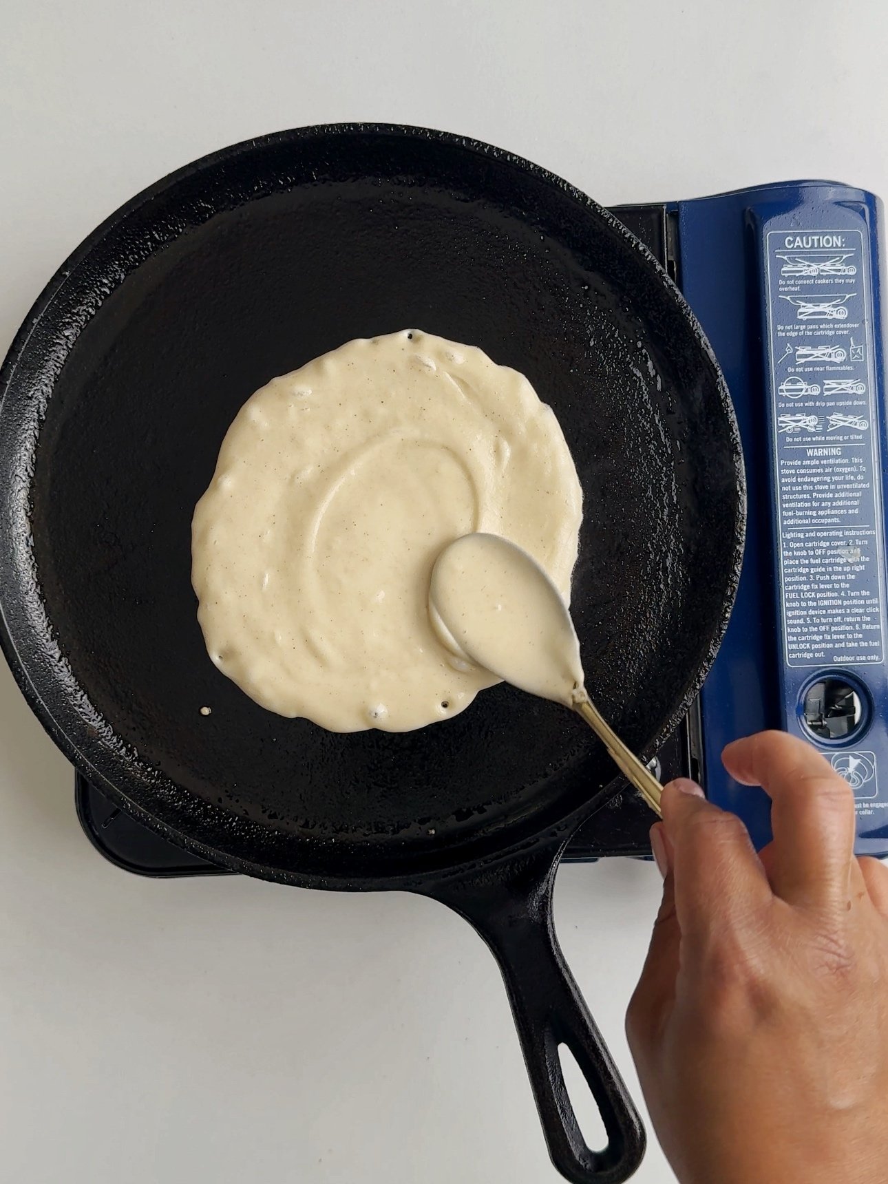 Spreading the batter on a taw with a spoon