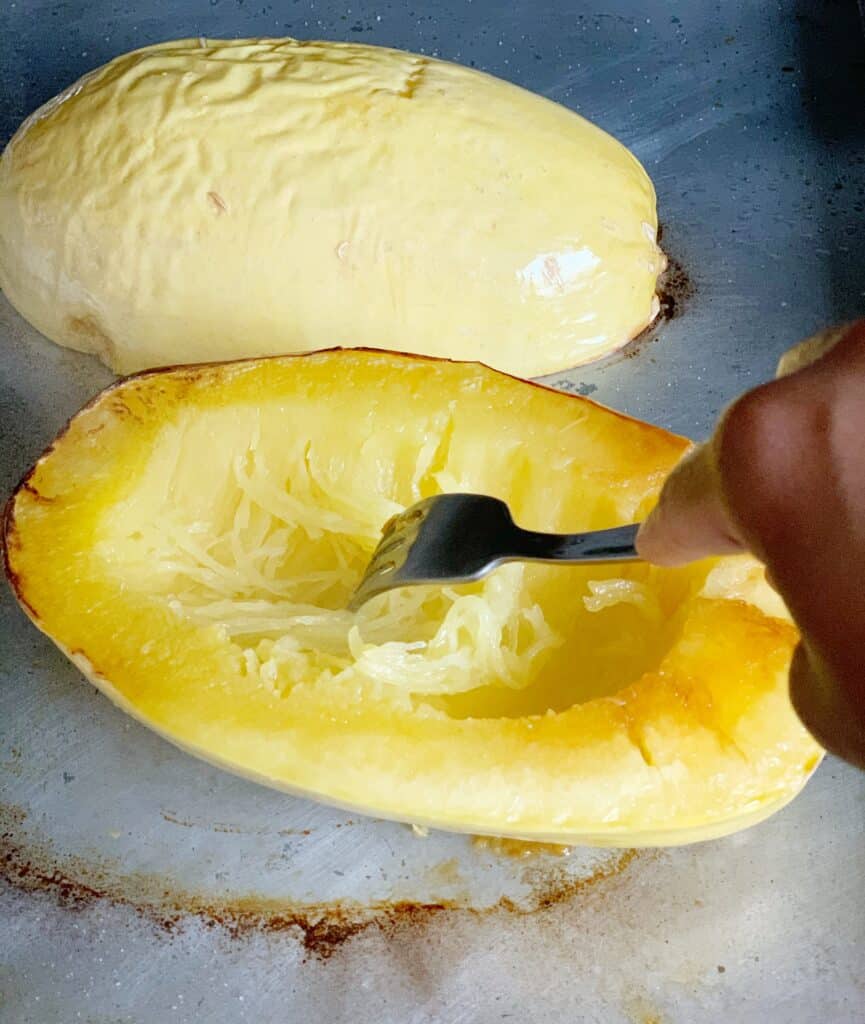 a fork inserted into the center of roasted spaghetti squash