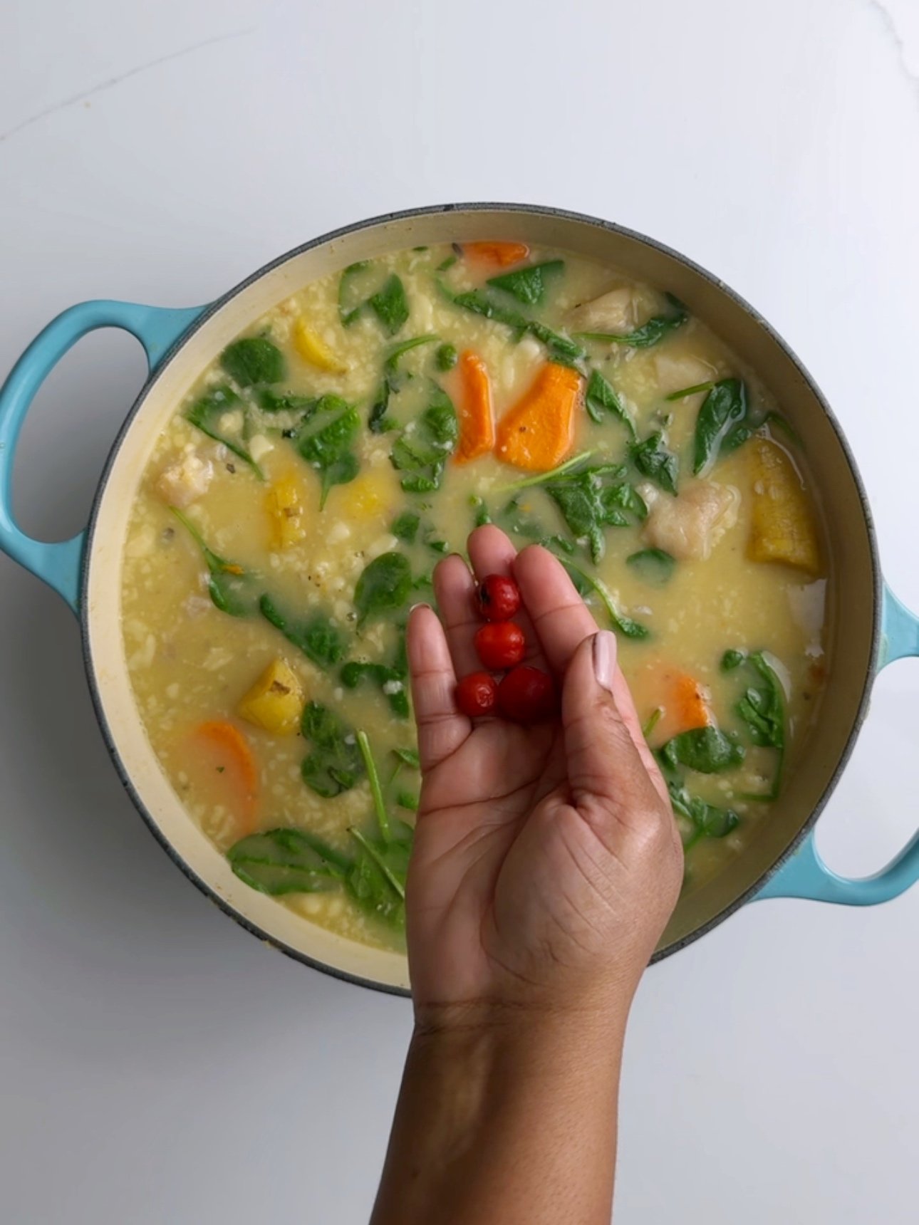Adding wiri wiri peppers to the soup
