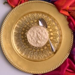 Kheer in glass bowl on a golden plate