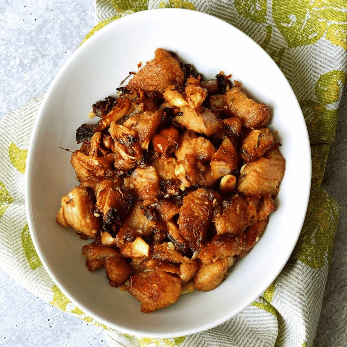 Garlic pork in a white bowl on a green napkin