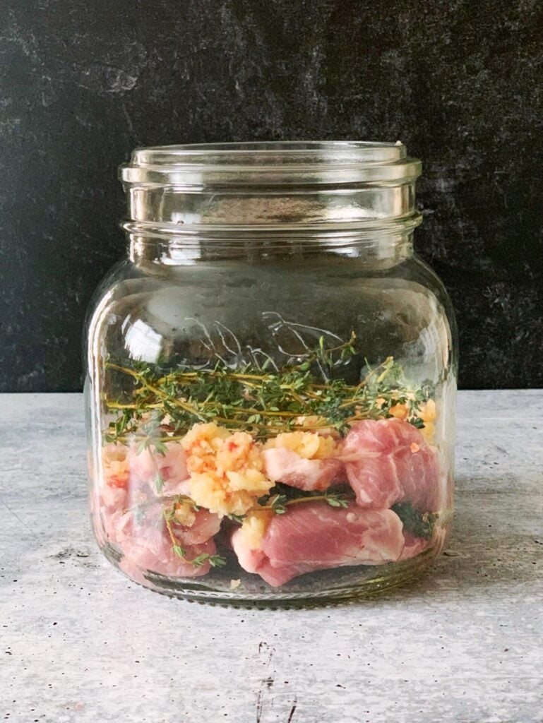pork and seasoning layed in a mason jar