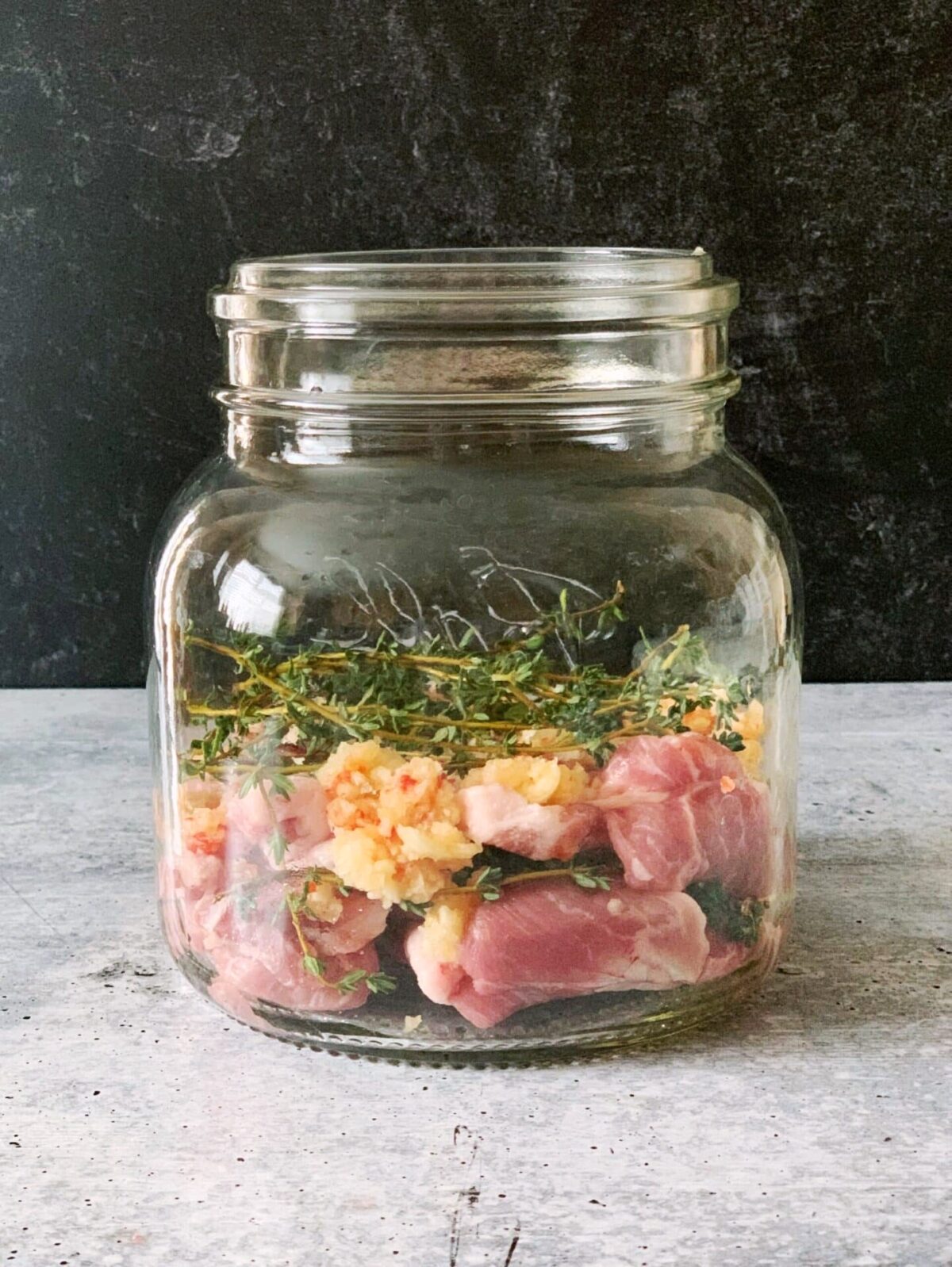 pork and seasoning layered in a mason jar for Guyanese garlic pork