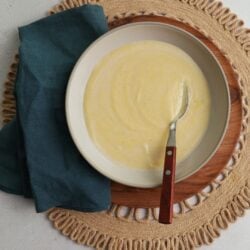 A bowl filled with cornmeal porridge with a spoon sitting in it.