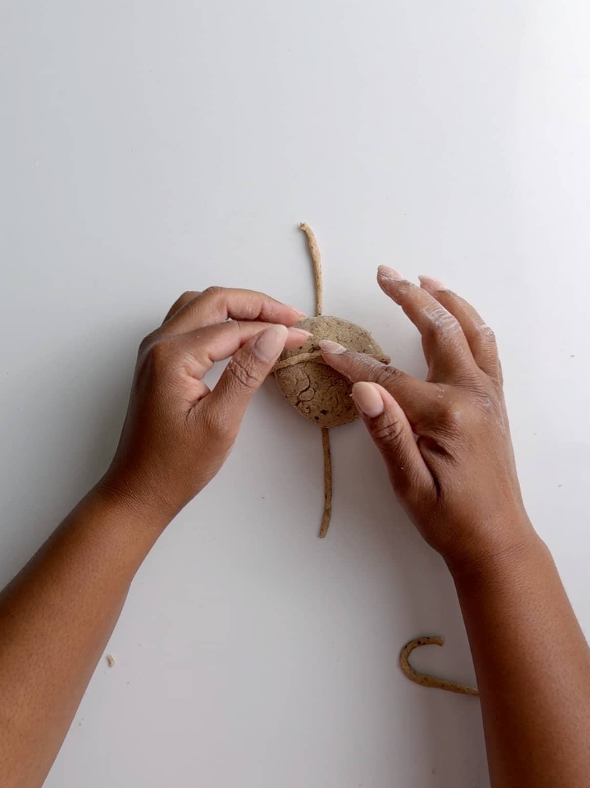 Adding a dough ball to the cross dough on a white surface