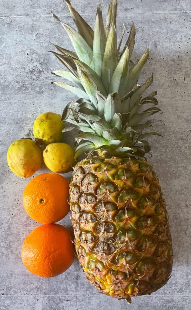 ingredients for flutie recipe: a full pineapple, oranges, and guavas