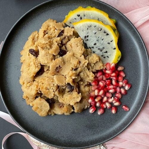 gluten free parsad, pomegranate and yellow dragon fruit on a gray plate
