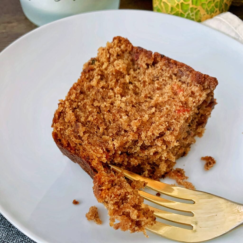 plated slice of fruit cake with a fork inserted