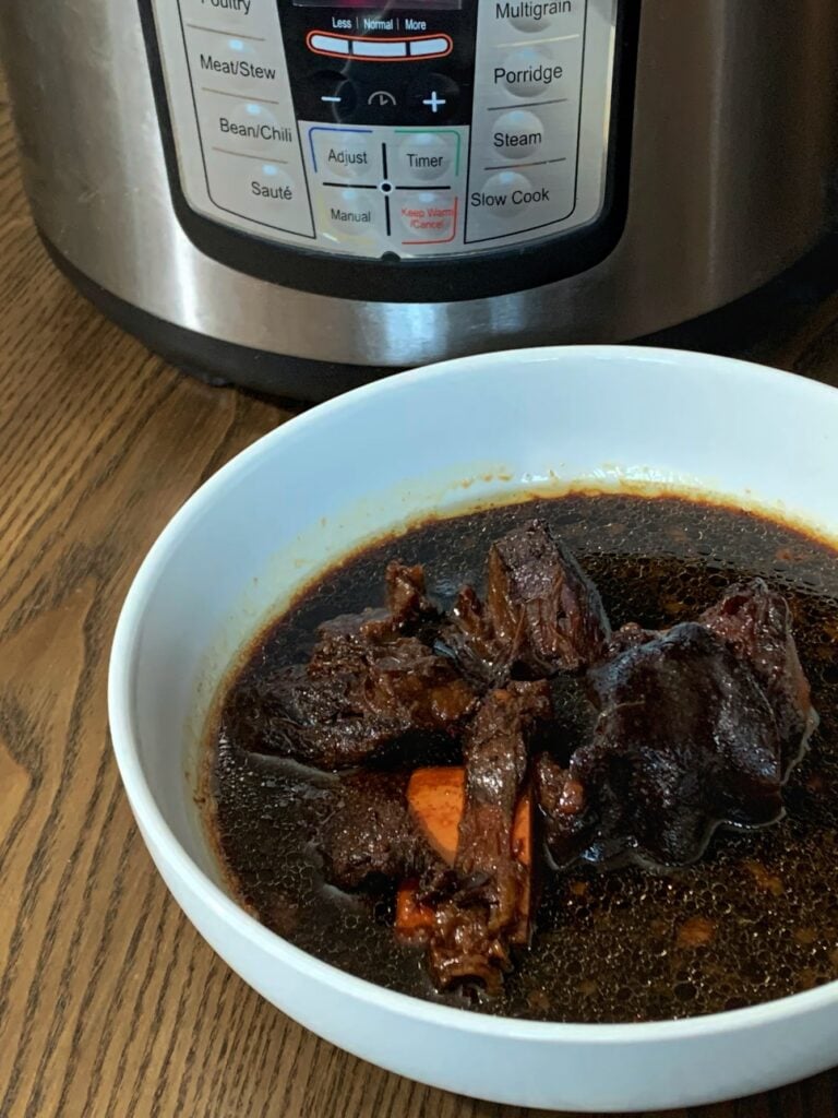 a bowl of pepperpot with an instant pot in the background 