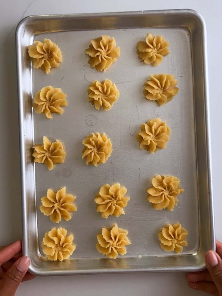 Piped cheese rosettes on a sheetpan