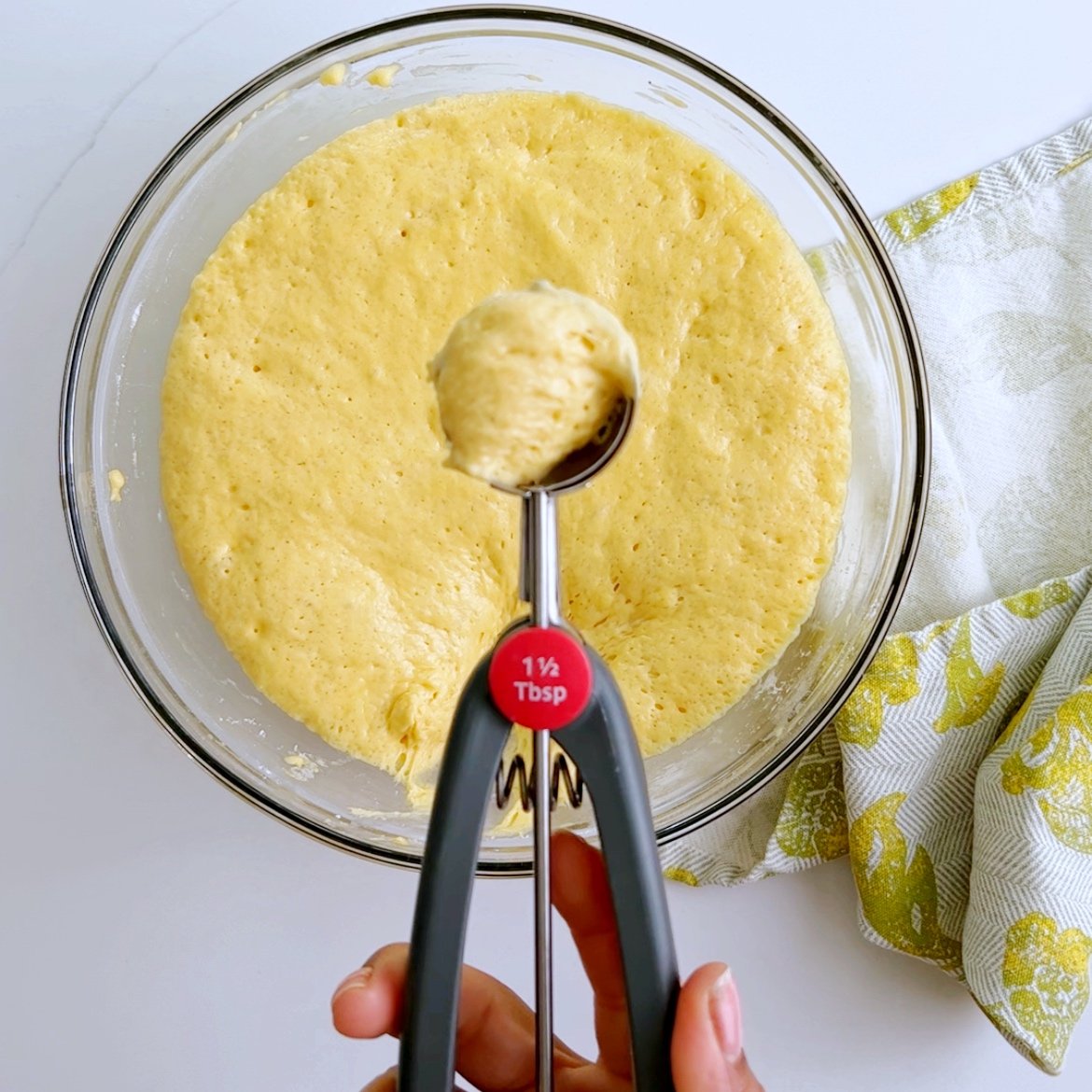 using a cookie scoop to scoop up batter
